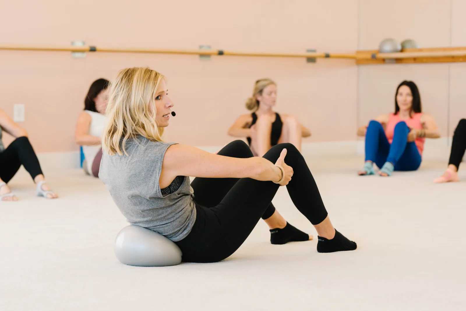 An instructor leading seated core work with the class following behind her